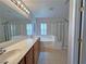 Bathroom with dual sinks, soaking tub, and glass-enclosed shower at 9034 Grenache St, Las Vegas, NV 89148