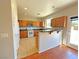 Well-lit kitchen featuring wood cabinets, tile floors, modern appliances, and breakfast bar at 9034 Grenache St, Las Vegas, NV 89148
