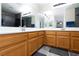 Bathroom with double sinks, wood cabinetry and a view of the shower, creating a calming atmosphere at 9039 Alex Creek Ave, Las Vegas, NV 89149