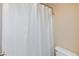 Close up of bathroom shower with white shower curtain, and toilet at 9039 Alex Creek Ave, Las Vegas, NV 89149