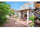 Backyard with covered patio, brick pavers, string lights, and desert landscaping at 9348 Buckhaven Dr, Las Vegas, NV 89117