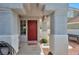 Covered front porch with red door and desert-style landscaping offers a warm welcome at 9348 Buckhaven Dr, Las Vegas, NV 89117