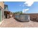 The backyard features an above ground pool, brick patio and a wooden pergola at 9690 Langden Brook St, Las Vegas, NV 89178