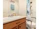 Bathroom featuring a wooden vanity, white sink, and shower with a shower chair and grab bar at 9690 Langden Brook St, Las Vegas, NV 89178