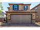 Charming home with a tiled roof, tan stucco exterior, and a convenient two-car garage with brick driveway at 9690 Langden Brook St, Las Vegas, NV 89178