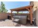 Hot tub on brick patio under wooden pergola with barbecue and low block fence at 9690 Langden Brook St, Las Vegas, NV 89178