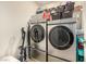 Well-equipped laundry room with front loading stainless washer and dryer and storage baskets at 9690 Langden Brook St, Las Vegas, NV 89178