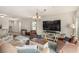 Well-lit open-concept living room with plush seating, stylish decor, and a smooth transition to the kitchen at 9690 Langden Brook St, Las Vegas, NV 89178