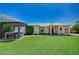 Expansive backyard with artificial grass, outdoor kitchen with grill, and covered patio at 983 Cutter St, Henderson, NV 89011