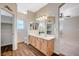 Bathroom featuring dual sinks, wood-style tile flooring, and walk-in closet entrance at 983 Cutter St, Henderson, NV 89011