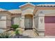 Close up of front entrance with desert landscaping, a tiled walkway, and a view of the two car garage at 983 Cutter St, Henderson, NV 89011
