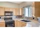 Kitchen features granite countertops, wooden cabinets, stainless steel appliances, and tile backsplash at 983 Cutter St, Henderson, NV 89011