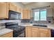 Kitchen features granite countertops, wooden cabinets, stainless steel appliances, and tile backsplash at 983 Cutter St, Henderson, NV 89011