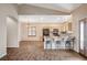 Open concept kitchen with breakfast bar, tile backsplash, and stainless steel appliances, adjoining the living room at 983 Cutter St, Henderson, NV 89011