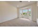 This carpeted bedroom features three large windows looking out on the front yard at 10421 Linfield Pl, Las Vegas, NV 89134