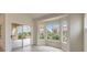 Bright living room featuring sliding glass doors, a bank of windows, and neutral paint throughout at 10421 Linfield Pl, Las Vegas, NV 89134