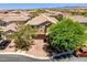 Aerial view of the home featuring lush landscaping, two car garage and warm color palette at 10474 Palmadora St, Las Vegas, NV 89178