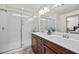 Bright bathroom with double sink vanity, large mirror, and glass-enclosed shower at 10474 Palmadora St, Las Vegas, NV 89178