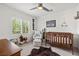Charming Bedroom with a crib, rocking chair, cactus decor, and a ceiling fan at 10474 Palmadora St, Las Vegas, NV 89178