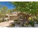 Charming two-story home with stone accents, a two-car garage, and mature trees in a landscaped yard at 10474 Palmadora St, Las Vegas, NV 89178