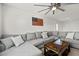 Bright living room featuring a large sectional sofa, rustic coffee table, and modern ceiling fan at 10474 Palmadora St, Las Vegas, NV 89178