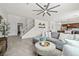 Bright and airy living room featuring tile floors, a large ceiling fan, and a comfortable gray sectional sofa at 10474 Palmadora St, Las Vegas, NV 89178