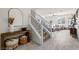 Entryway view of a bright living room with tile floors, white staircase, and comfortable gray sectional sofa at 10474 Palmadora St, Las Vegas, NV 89178