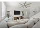 Cozy living room with large sectional sofa, tv, ceiling fan, and ample natural light at 10474 Palmadora St, Las Vegas, NV 89178