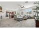 Bright living room with tile floors, a large gray sectional, and dining area with wood table and chairs at 10474 Palmadora St, Las Vegas, NV 89178