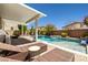 Beautiful backyard pool with waterfall, lounge chairs and patio furniture under a covered patio at 10474 Palmadora St, Las Vegas, NV 89178