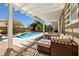 Beautiful pool with spa, waterfall, and a cozy patio with comfortable seating under a pergola at 10474 Palmadora St, Las Vegas, NV 89178