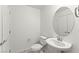 Clean, well-lit half bathroom featuring a pedestal sink and round mirror at 1103 Tektite Ave, Henderson, NV 89011