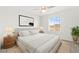 A well-lit staged bedroom showcasing a bed, two end tables, artwork, a plant, and a window at 1103 Tektite Ave, Henderson, NV 89011