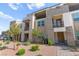 Exterior view of a townhouse featuring stacked stone accents, balconies, and lush landscaping for an inviting curb appeal at 1103 Tektite Ave, Henderson, NV 89011
