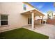 An open backyard featuring a covered patio, artificial turf, and brick perimeter at 11044 Camden Bay St, Las Vegas, NV 89179