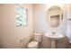 Cozy powder room with pedestal sink, oval mirror, and a window for natural light at 11044 Camden Bay St, Las Vegas, NV 89179