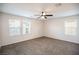 Bright bedroom featuring plush carpet, ceiling fan, and three large windows at 11044 Camden Bay St, Las Vegas, NV 89179
