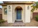 Close-up of a front door adorned with a wreath, flanked by sconces and a stone-paved path at 11044 Camden Bay St, Las Vegas, NV 89179