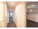 Bright hallway leading to carpeted bedrooms with natural light and dark wood floored room at 11044 Camden Bay St, Las Vegas, NV 89179