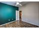 A spacious bedroom featuring wood-look floors and a teal accent wall for a unique look at 1554 Ward Frontier Ln, Henderson, NV 89002