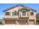 Townhome with a balcony, three garage doors, and a stucco facade at 1554 Ward Frontier Ln, Henderson, NV 89002