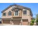 Townhome with a balcony, three garage doors, and a stucco facade at 1554 Ward Frontier Ln, Henderson, NV 89002
