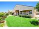 Expansive backyard with synthetic grass, red roses, desert landscaping, covered patio, and mountain views at 2164 Noonday Ct, Henderson, NV 89052