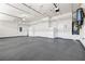 A well-lit, spacious three car garage with gray epoxy flooring, and ample storage and utilities at 2164 Noonday Ct, Henderson, NV 89052