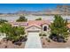 Stunning aerial shot showcases a well-manicured single-story home with red roof tiles and mountain backdrop at 2315 Sun Cliffs St, Las Vegas, NV 89134