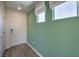 Bright entryway with green accent wall, laminate flooring, and white roman shades at 2646 Begonia Falls Ave # 41, North Las Vegas, NV 89081