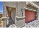 Home exterior featuring a front door, red garage door, stone pathway, and stucco walls at 2646 Begonia Falls Ave # 41, North Las Vegas, NV 89081