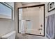 Clean bathroom featuring a bathtub with glass doors, white subway tile, toilet, and towel bar at 2651 Deep Canyon St, Henderson, NV 89044