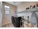 Well-organized laundry room featuring a washer, dryer, storage shelf, and ironing board at 2651 Deep Canyon St, Henderson, NV 89044