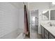 Bathroom with a shower-tub combo, white subway tile, and gray vanity at 2717 Cool Lilac Ave, Henderson, NV 89052